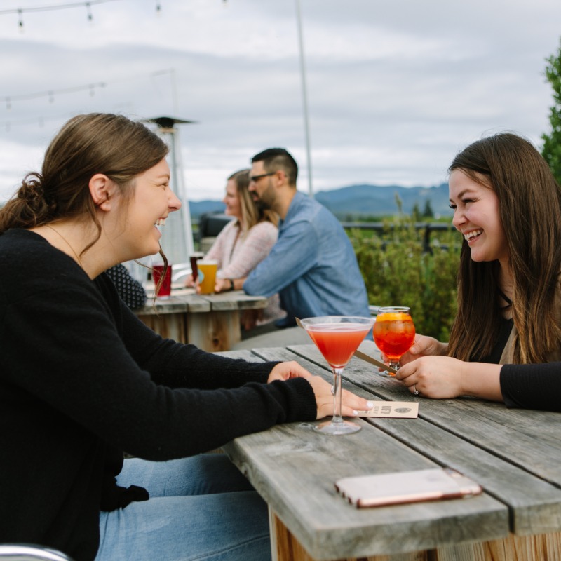 Sky High Brewing, Corvallis, Oregon - Two women enjoy drinks and views of the Coast Range at Sky High's rooftop bar